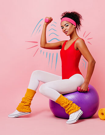 a photo of someone sitting on a exercise ball flexing their bicep